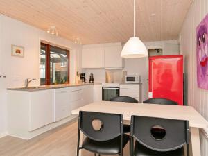 cocina con armarios blancos y nevera roja en Seaside Retreat in Hvalpsund-By Traum, en Farsø