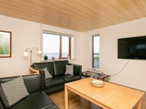 una sala de estar con un sofá y una mesa en Seaside Retreat in Hvalpsund-By Traum, en Farsø