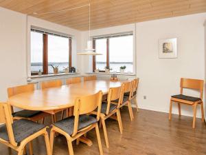een eetkamer met een houten tafel en stoelen bij Holiday home Farsø XI in Farsø