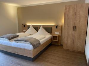 ein Schlafzimmer mit einem großen Bett und einem Holzschrank in der Unterkunft Haus Schatzgarten in Traben-Trarbach