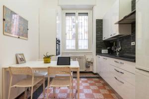 a kitchen with a table with chairs and a laptop on it at Piola Flexyrent apt. A.C. WiFi in Milan