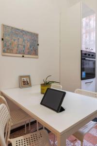 a laptop computer sitting on a white table with chairs at Piola Flexyrent apt. A.C. WiFi in Milan