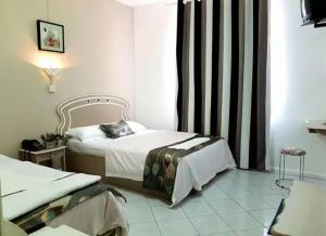 a hotel room with two beds and a window at Euro Vacances Guest House in Roches Brunes