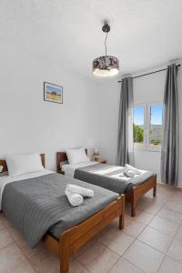 1 dormitorio con 2 camas y ventana en Bella-Maria at Aptera with mountain and sea view !! en La Canea