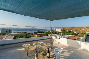 un patio con mesa y sillas en la azotea en Bella-Maria at Aptera with mountain and sea view !! en La Canea