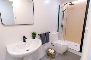 a bathroom with a sink and a toilet and a mirror at Koala Hostel in Alicante