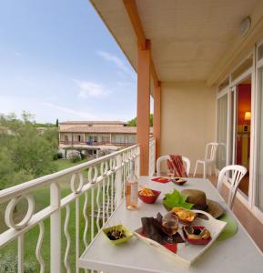 - un balcon avec une table et de la nourriture dans l'établissement SOWELL Family Grau du Roi, au Grau-du-Roi