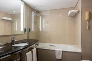 a bathroom with a sink and a bath tub at Vila Gale Cascais in Cascais