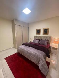 a bedroom with a large bed with a red rug at Beautifull New 2 Bedroom Apartment in Amman in Amman