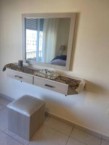 a bathroom with a mirror and a sink and a stool at Exquisite and Cozy 2 Bedroom 2 bath Apartment in Amman