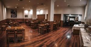 a restaurant with wooden floors and tables and chairs at Hotel Americano in Buenos Aires