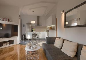een woonkamer met een bank en een tafel bij Apartment Leki - newly renovated, modern city spot in Pula