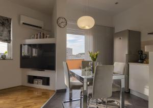 een eetkamer met een tafel en stoelen en een klok bij Apartment Leki - newly renovated, modern city spot in Pula