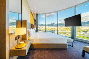 Grand Hyatt Bogota في بوغوتا: غرفة فندقية بسرير ونافذة كبيرة