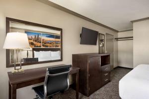 a hotel room with a desk and a bed at Baymont by Wyndham Monterey Park in Monterey Park