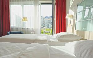 2 Betten in einem Hotelzimmer mit Fenster in der Unterkunft Park Inn by Radisson Linz in Linz