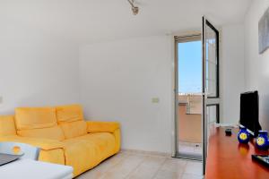 a living room with a yellow couch and a desk at L'appartamento di Giusi in Olbia