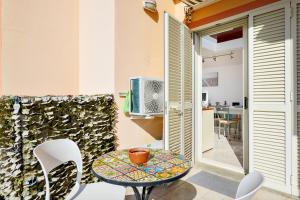 a patio with a table and chairs and a kitchen at L'appartamento di Giusi in Olbia