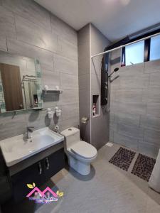 a bathroom with a toilet and a sink at Desaru Dhancell Executive Homestay All Bedrooms With NETFLIX in Desaru