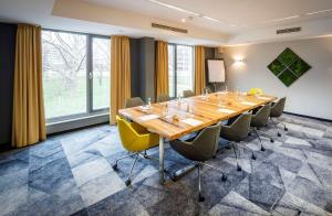 einen Konferenzraum mit einem langen Tisch und Stühlen in der Unterkunft Lanzcarré Hotel Mannheim, a member of Radisson Individuals in Mannheim