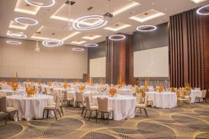 a large banquet hall with white tables and chairs at Radisson Blu Hotel, Juba in Juba