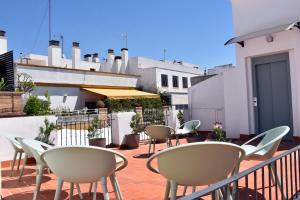 a patio with chairs and tables on a balcony at Alegoría Coliving Experience Residencia in Seville