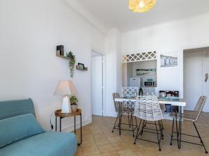 ein Wohnzimmer mit einem Sofa, einem Tisch und Stühlen in der Unterkunft Apartment Foncillon by Interhome in Royan