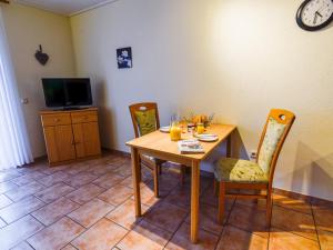 ein Esszimmer mit Tisch und Stühlen und einem Fernseher in der Unterkunft Apartment Tjalkstrasse-3 by Interhome in Norddeich