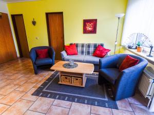 ein Wohnzimmer mit zwei Stühlen und einer Couch und einem Tisch in der Unterkunft Apartment Tjalkstrasse-3 by Interhome in Norddeich