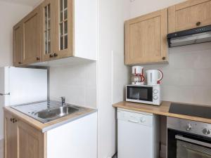 een kleine keuken met een wastafel en een magnetron bij Apartment Le Petit Robinson-2 by Interhome in La Richardais