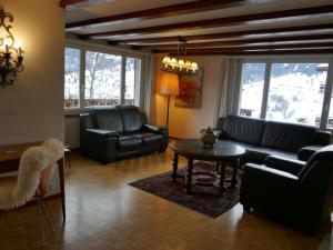 uma sala de estar com sofás, uma mesa e janelas em Apartment Chalet Shangri La by Interhome em Grindelwald