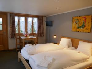 Habitación de hotel con 2 camas y mesa en Apartment Schwendihus by Interhome, en Grindelwald