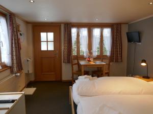 a hotel room with two beds and a table at Apartment Schwendihus by Interhome in Grindelwald