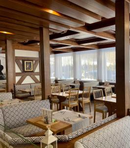 a restaurant with couches and tables and windows at Hotel HAAS in Bad Gastein