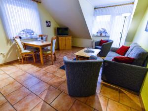 a living room with a couch and a table and chairs at Apartment Tjalkstrasse-2 by Interhome in Norddeich