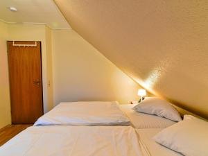 Bett in einem Zimmer mit Dachschräge in der Unterkunft Apartment Tjalkstrasse-2 by Interhome in Norddeich