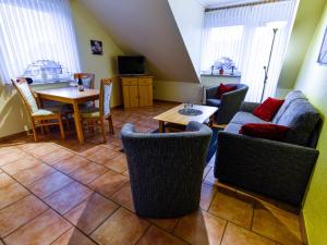 a living room with a couch and a table and chairs at Apartment Tjalkstrasse-2 by Interhome in Norddeich