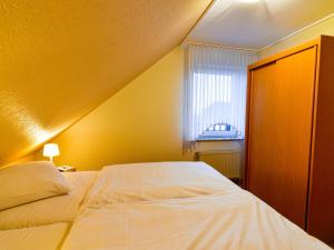 ノルトダイヒにあるApartment Tjalkstrasse-2 by Interhomeのベッドルーム(白いベッド1台、窓付)