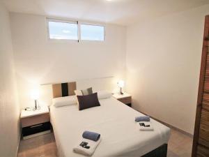a bedroom with a large white bed with a window at Apartment Coblanca III in Benidorm