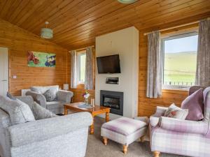 a living room with couches and a fireplace at Chalet Loch Leven Lodge 6 by Interhome in Kinross