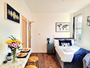 um quarto com uma cama e uma mesa com comida em Modern Apt near Train Station and Ideal for Long Stays em Leicester