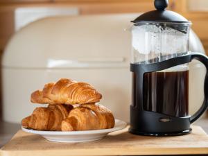 a coffee maker with croissants and a plate of croissants at Chalet Loch Leven Lodge 6 by Interhome in Kinross