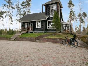 a bike parked in front of a black house at Holiday Home Le club 44 by Interhome in Kausala