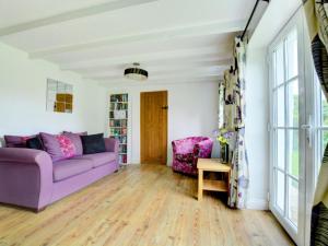 Saint IsseyにあるHoliday Home St Issay by Interhomeの紫色のソファとテーブル付きのリビングルーム
