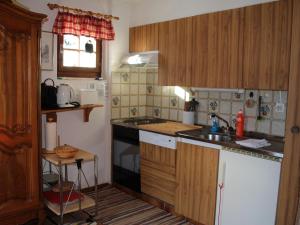 uma pequena cozinha com armários de madeira e um lavatório em Chalet Henri by Interhome em Moleson