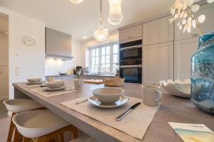 a kitchen with a large table with chairs and a blue vase at Landhaus Marie in Oldsum +49 photos