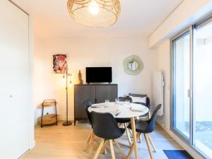 una sala da pranzo con tavolo, sedie e TV di Studio le Galion-2 by Interhome ad Arcachon