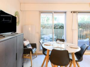 una sala da pranzo con tavolo, sedie e televisione di Studio le Galion-2 by Interhome ad Arcachon