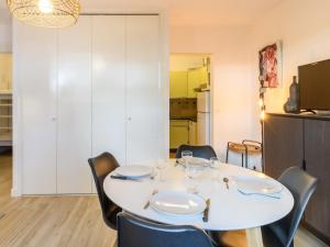 una sala da pranzo con tavolo e sedie bianchi di Studio le Galion-2 by Interhome ad Arcachon