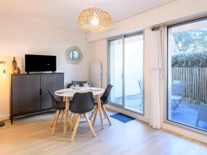 una sala da pranzo con tavolo, sedie e televisione di Studio le Galion-2 by Interhome ad Arcachon Altre 15 foto